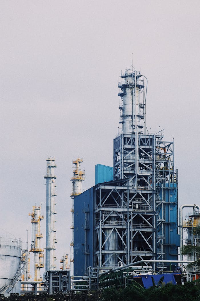 A large industrial plant with towering smokestacks set against a cloudy sky, illustrating industry and production.