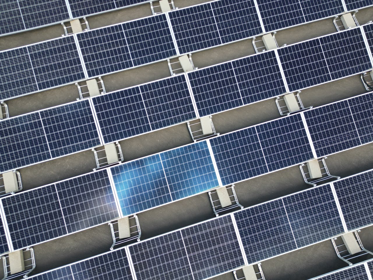 Aerial view of a large array of solar panels on a rooftop, utilizing renewable energy.